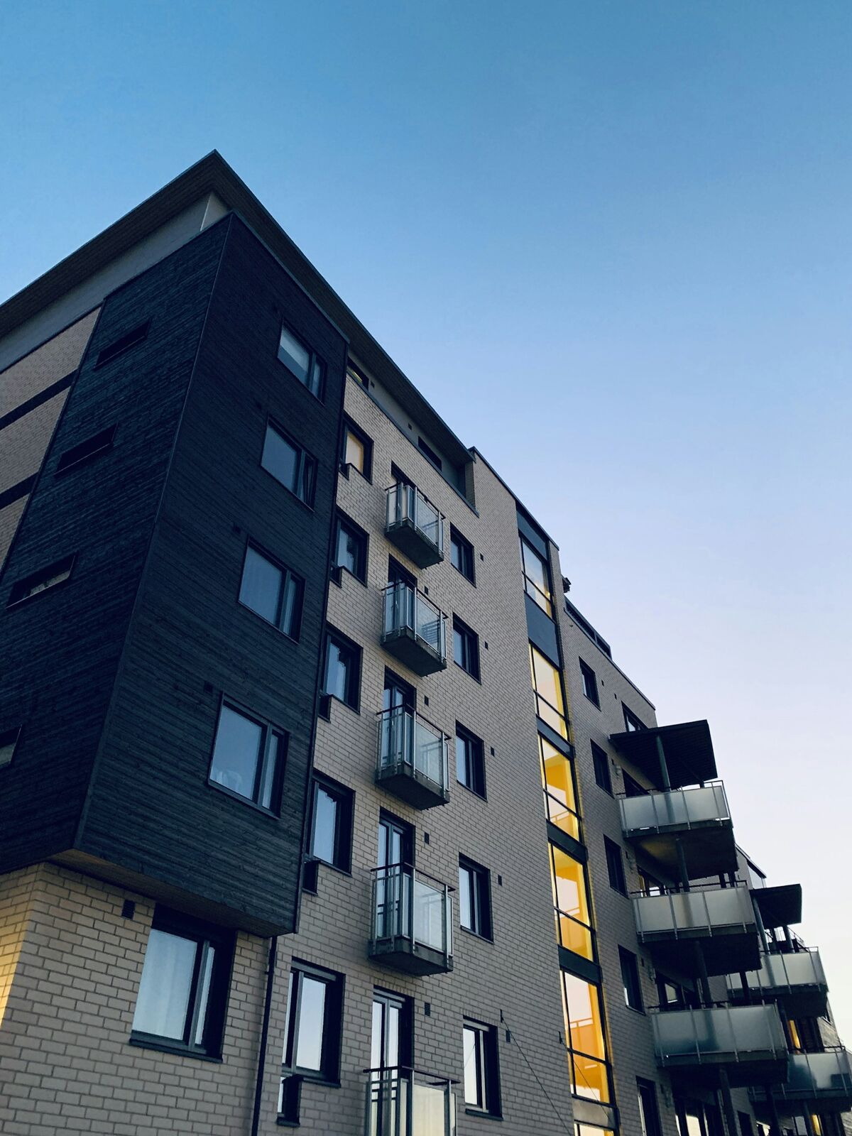 An apartment block at dusk with lit balconies